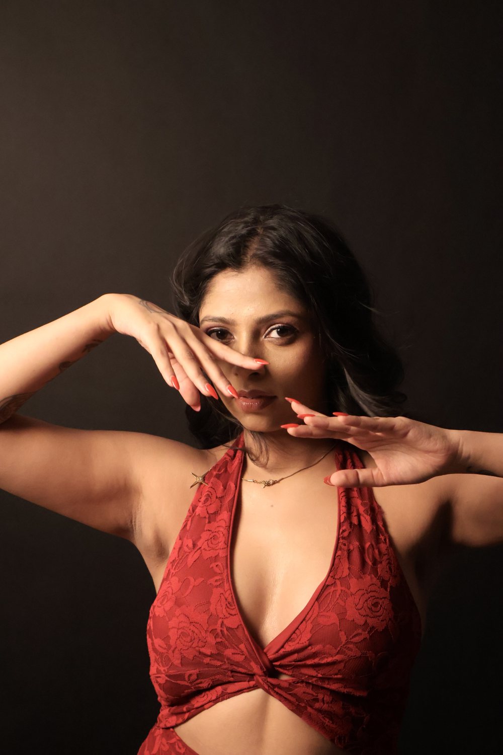 Mrunalini in red lace, hands framing her face